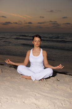 Young beautiful woman during fitness on sea beach 