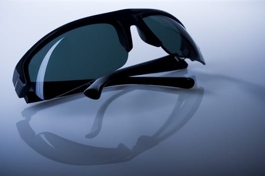 Black sunglasses on reflective dark background