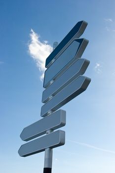 Signpost against blue sky with blank direction arrows