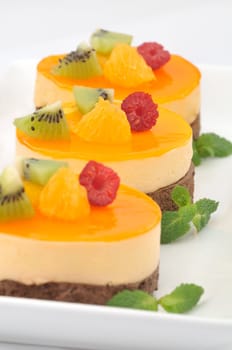 Trio of chocolate and orange cakes decorated with fruits - focus on middle cake
