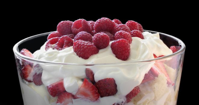 a luscious dessert of cake layered with fresh strawberries and whipped cream, topped with fresh raspberries
