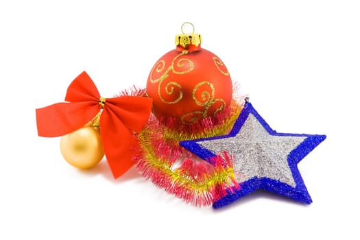 Two christmas balls of red and yellow colors and a silver star with blue edges on white