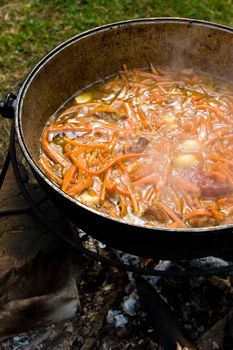 Cooking the traditional Uzbec pilaf in cauldron on fire