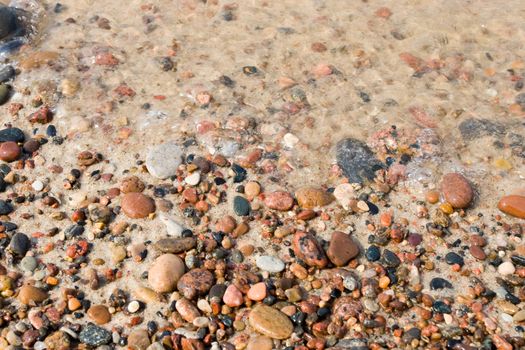 Wet pebbles on a beach background