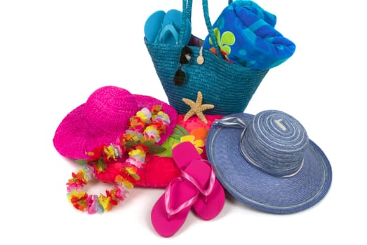 Colorful summer beachwear, flipflops, hat, orchids, sunglasses, towels, beach bag, and starfish