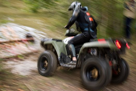 Sportsman riding quad bike at extreme competition