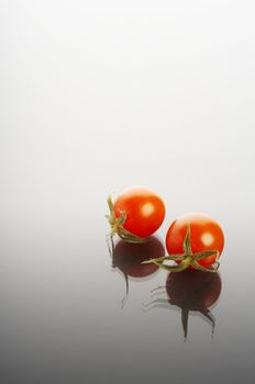 Miniature tomatoes on reflective surface