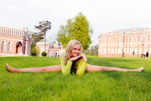 The young girl carrying out gymnastic exercise on a grass