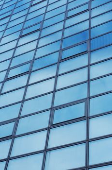 a Blue sky with clouds reflects on building windows 