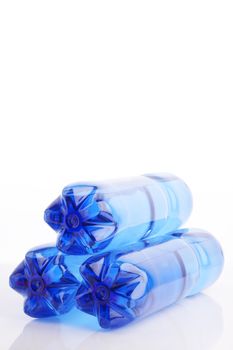 Isolated blue water bottles on white reflective background