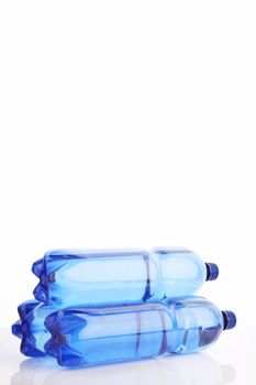 Isolated blue water bottles on white reflective background