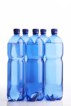 Isolated blue water bottles on white reflective background