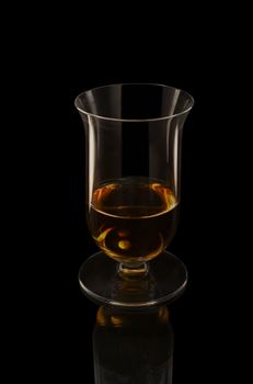 Rare single malt whiskey in a elegant tasting glass on the black background.