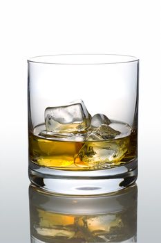 Front view of scotch glass on white reflective background