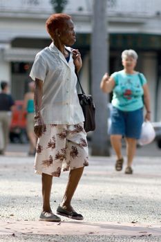 Old black woman walking outdoors. January 2008, Havana, Cuba.