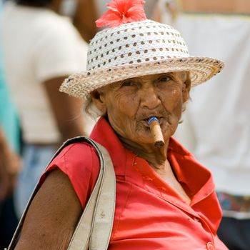 Old wrinkled woman smoking cigar. January 2008, Santiago-de-Cuba.