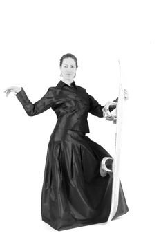 Portrait of a woman with long curly hair standing dressed for gala with a snowboard