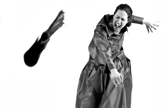 Portrait of a woman with long curly hair throwing her boot away hysterically