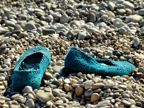 blue shoes on stony beach