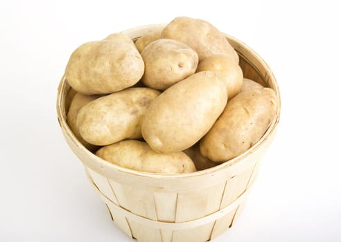 Potatoes in a woven basket on a white background