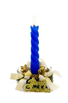 A blue Christmas candle decorated with candlestick and ribbons