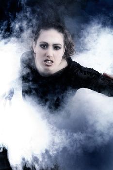 Portrait of a woman with long curly hair in smoke