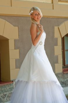 Beautiful blonde bride posing on the wall