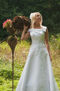 Beautiful blonde bride in white dress posing outdoor
