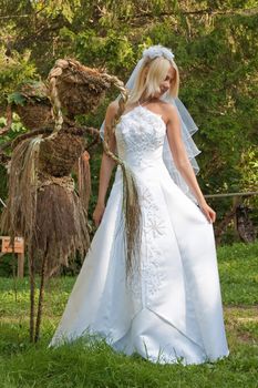 Beautiful blonde bride in white dress posing outdoor