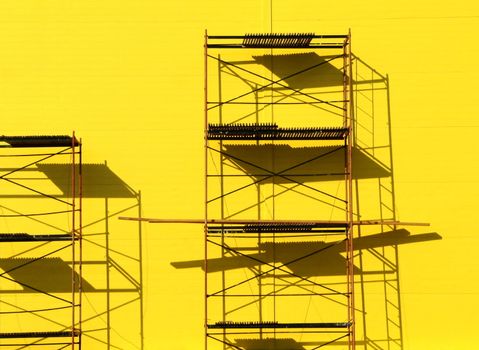 Constructions scaffolding on the yellow wall background