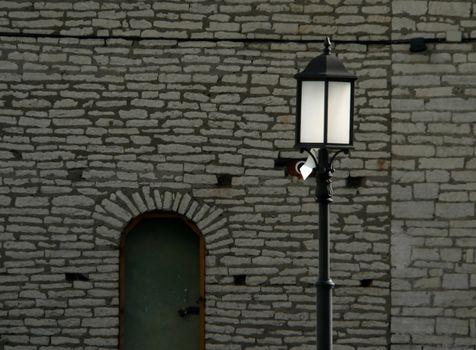 Old fashioned street lamp on wall background.