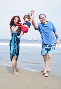 Young happy family together on the beach