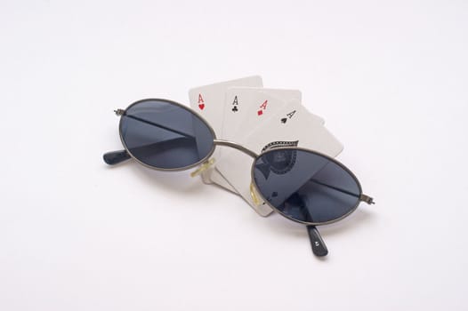 Four aces on an isolated background with a pair of sunglasses