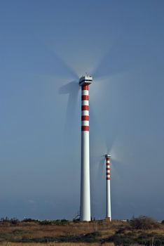 Two wind turbines generating energy - with motion blur