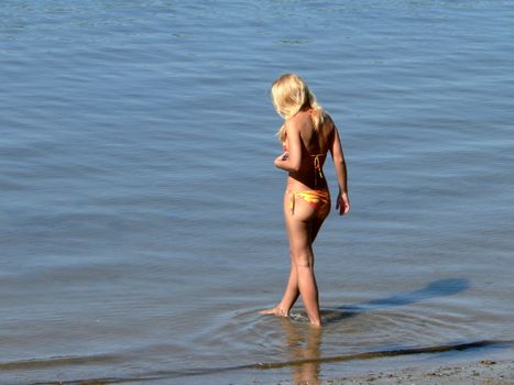 Young girl enter into the rivers water 2