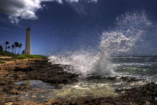 Wave crashing in front of Barber's Point lighthouse on Oahu, Hawaii.