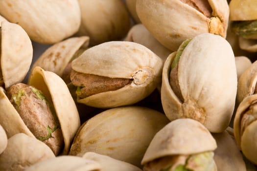 Pile of pistachio nuts close up - focus on one