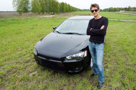 young man against the black car