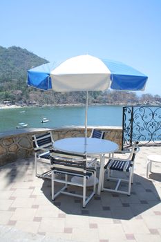 Restaurant table under umbrella overlooking beautiful ocean