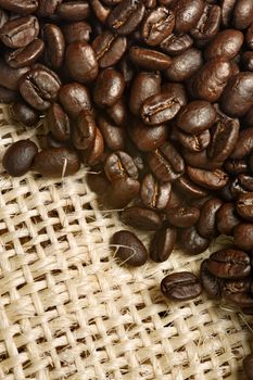 Background image of roasted coffee beans from a canvas sack.
