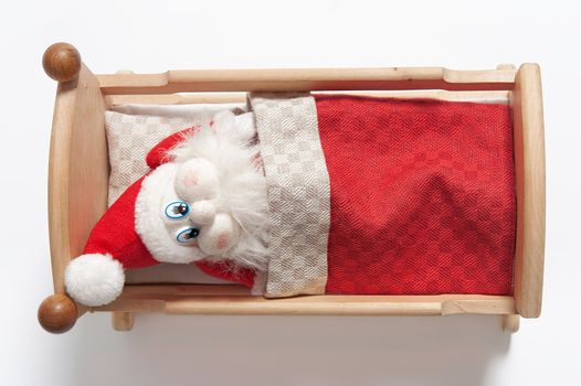 Gnome sleeping in wooden cradle isolated on white background