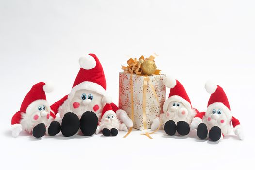 Christmas present and five gnomes isolated on white background