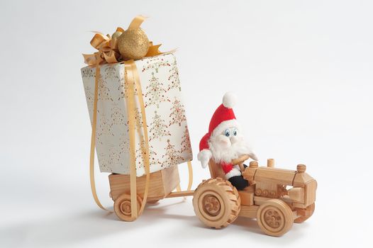 Gnome driving toy tractor with christmas present in trailer