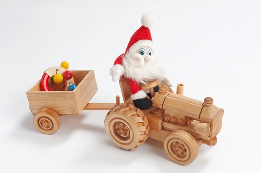 Gnome driving tractor with christmas toy in trailer