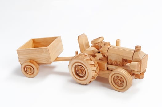 Wooden toy tractor with trailer on white isolated background