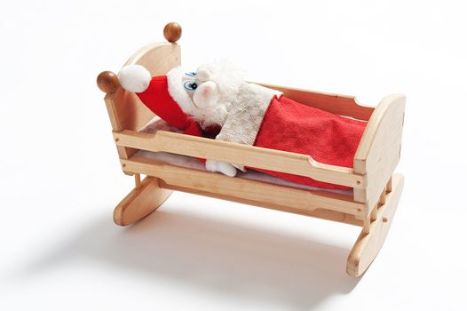 Gnome sleeping in wooden cradle isolated on white background