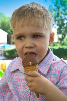 The little boy licks ice-cream a cone