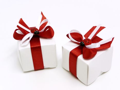 White gift boxes with red ribbons and ladybugs