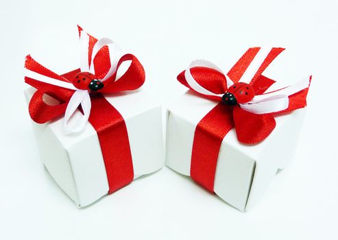 White gift boxes with red ribbons and ladybugs