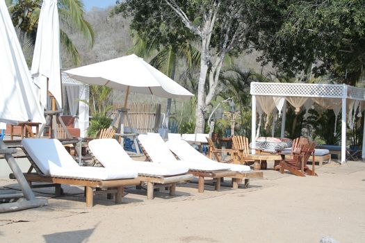 Beach front lounge chairs with umbrella and cabana